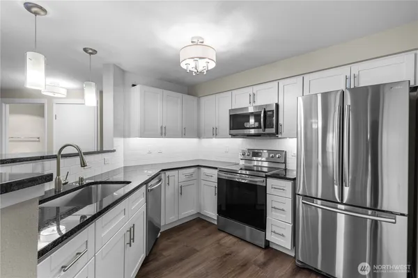a kitchen with a sink stainless steel appliances and refrigerator