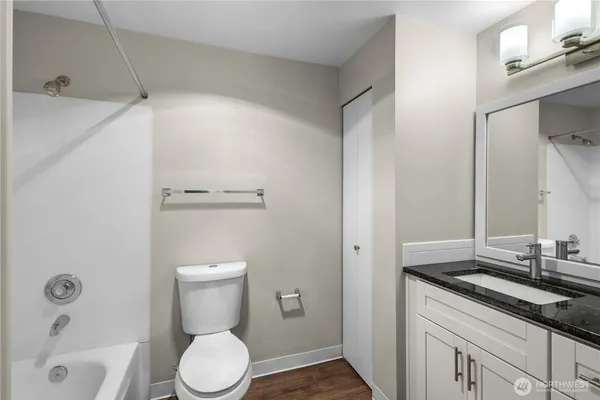 a bathroom with a granite countertop sink toilet and shower