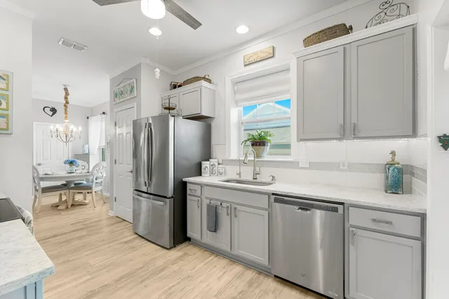 a kitchen with a sink a microwave a refrigerator and cabinets