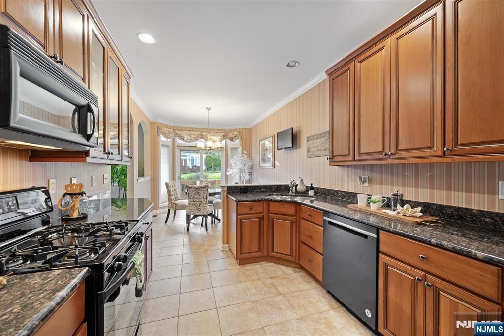 26 Chestnut Court Cedar Grove, NJ 07009 - Photo 12 of 42 a kitchen with stainless steel appliances granite countertop a stove top oven a sink dishwasher and cabinets with wooden floor