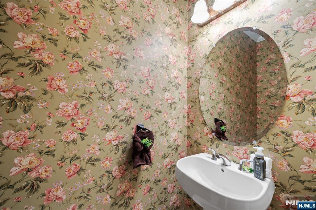 26 Chestnut Court Cedar Grove, NJ 07009 - Photo 18 of 42 a bathroom with a sink and mirror