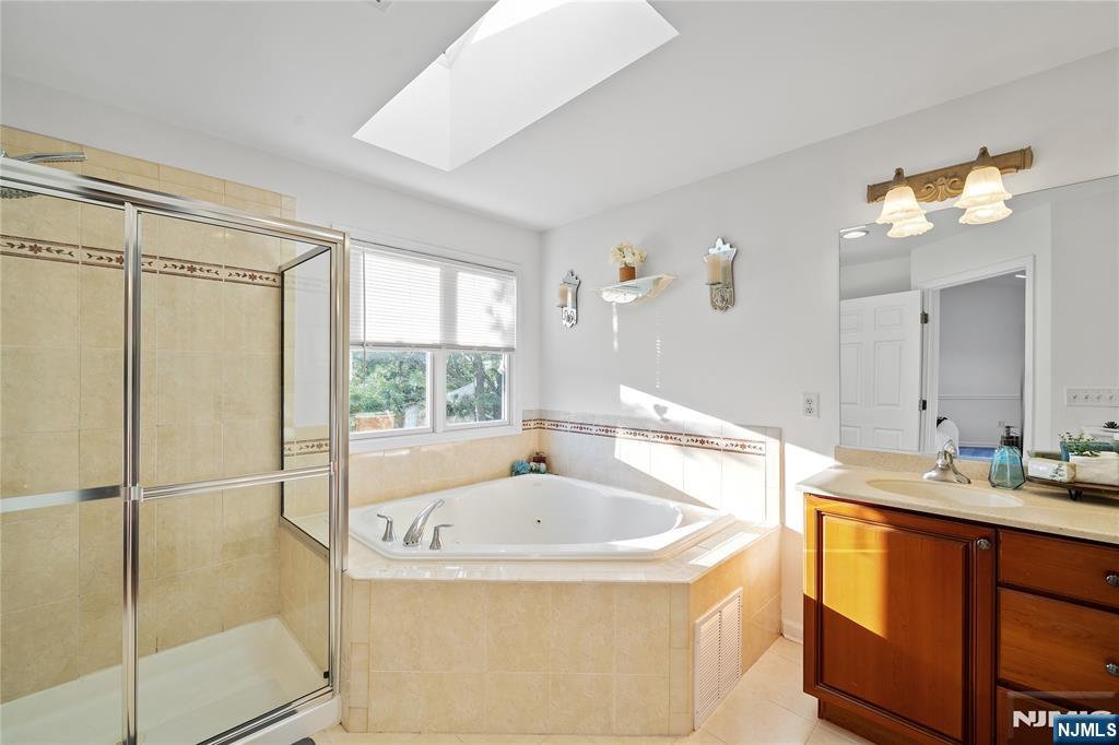 26 Chestnut Court Cedar Grove, NJ 07009 - Photo 24 of 42 a bathroom with a tub sink and mirror