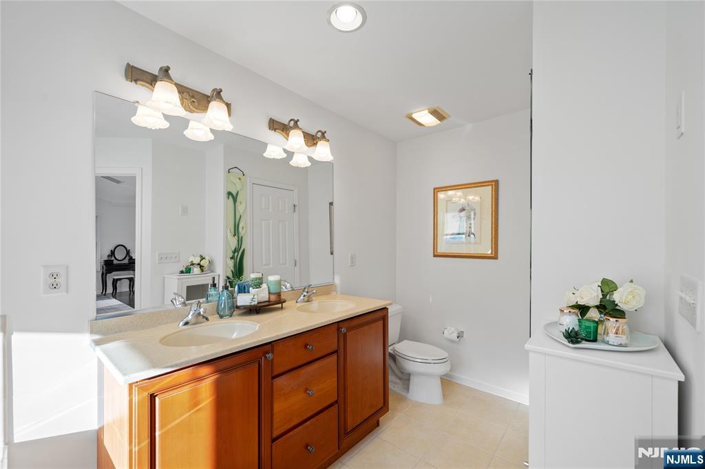 26 Chestnut Court Cedar Grove, NJ 07009 - Photo 25 of 42 a bathroom with a double vanity sink and a mirror
