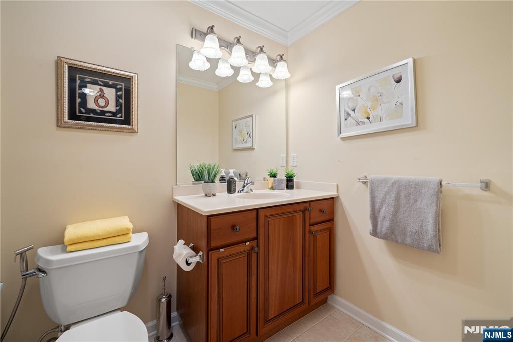 26 Chestnut Court Cedar Grove, NJ 07009 - Photo 32 of 42 a bathroom with a toilet a sink and mirror