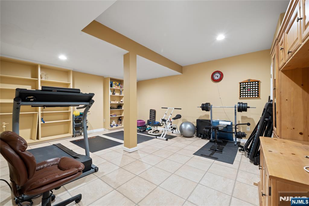 26 Chestnut Court Cedar Grove, NJ 07009 - Photo 37 of 42 a room with furniture a flat screen tv and gym equipment