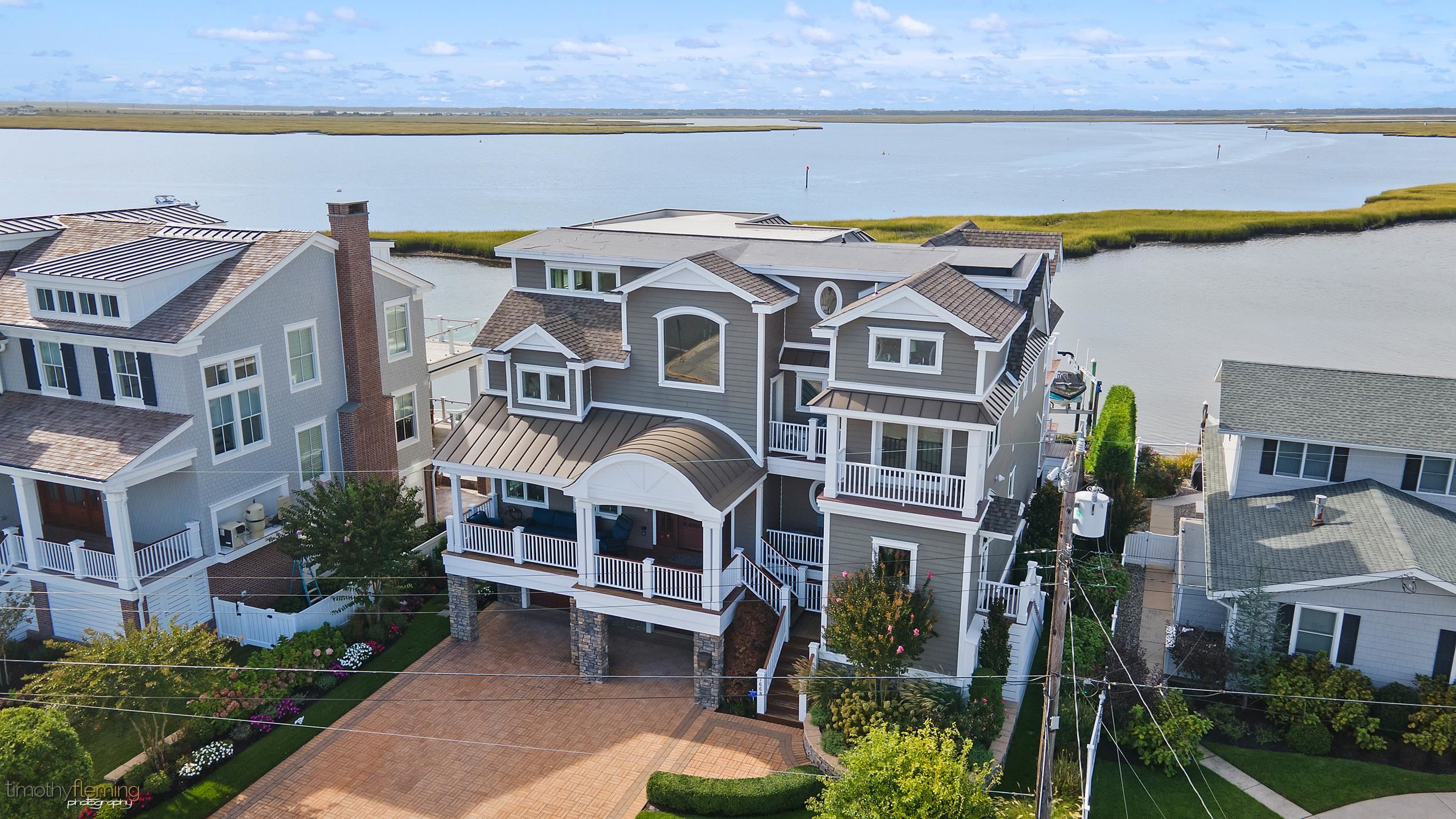 7668 Sunset Drive Avalon, NJ 08202 - Photo 2 of 49 a front view of a house with a garden and plants