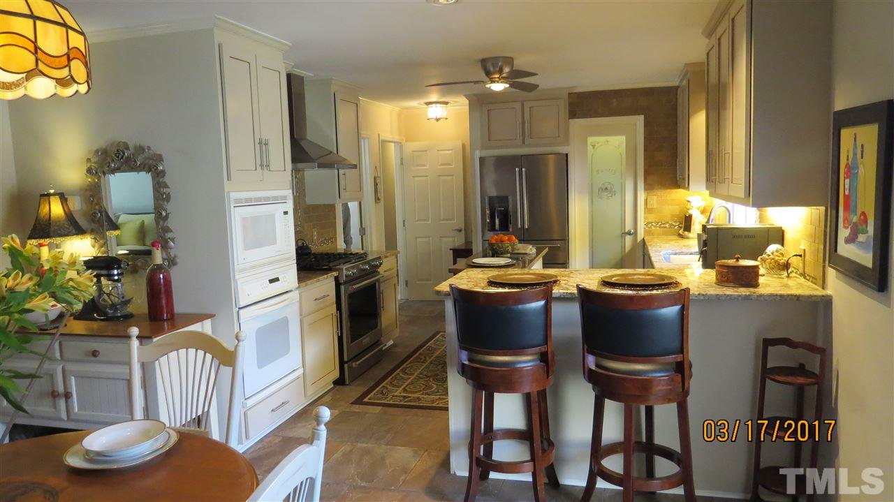 2758 Rue Sans Famille Raleigh, NC 27607 - Photo 4 of 12 a view of dining room and kitchen island with furniture