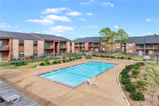 a view of a house with a yard and potted plants