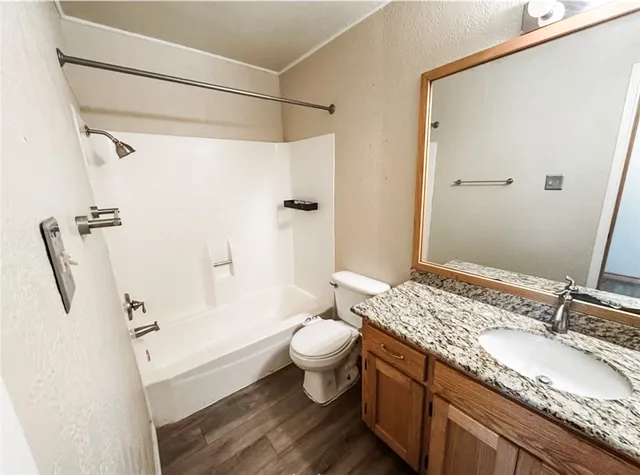 a bathroom with a granite countertop sink toilet and shower