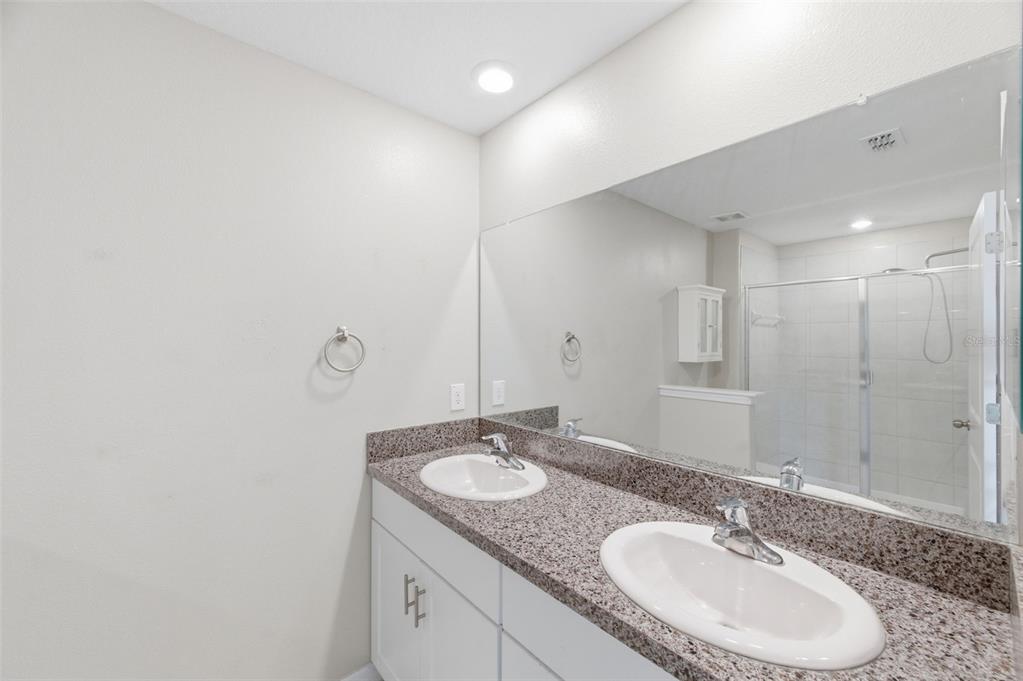 8606 Reedville Street New Port Richey, FL 34654 - Photo 31 of 100 a bathroom with a granite countertop sink and a mirror