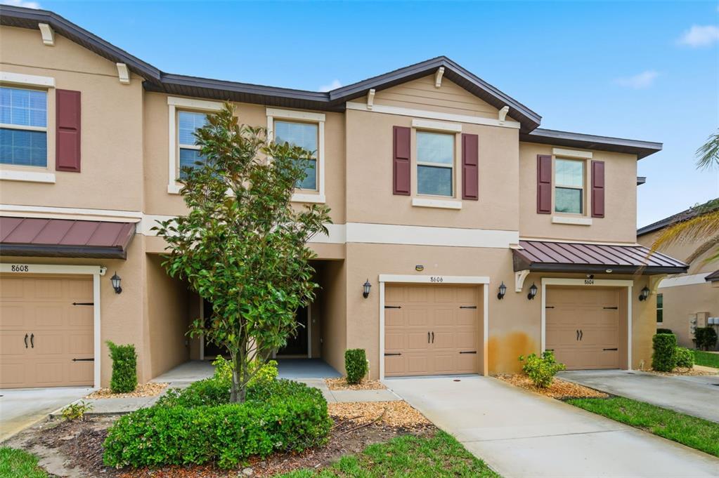 8606 Reedville Street New Port Richey, FL 34654 - Photo 4 of 100 a front view of a house with a yard and garage