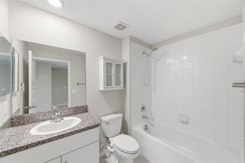 8606 Reedville Street New Port Richey, FL 34654 - Photo 42 of 100 a bathroom with a granite countertop sink toilet a mirror and shower