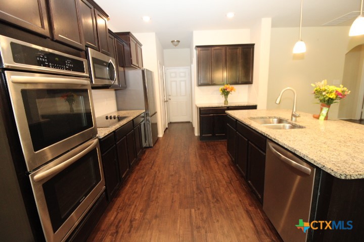 1202 Stonewall Ridge Harker Heights, TX 76548 - Photo 3 of 14 a kitchen with stainless steel appliances granite countertop a stove a sink and a microwave