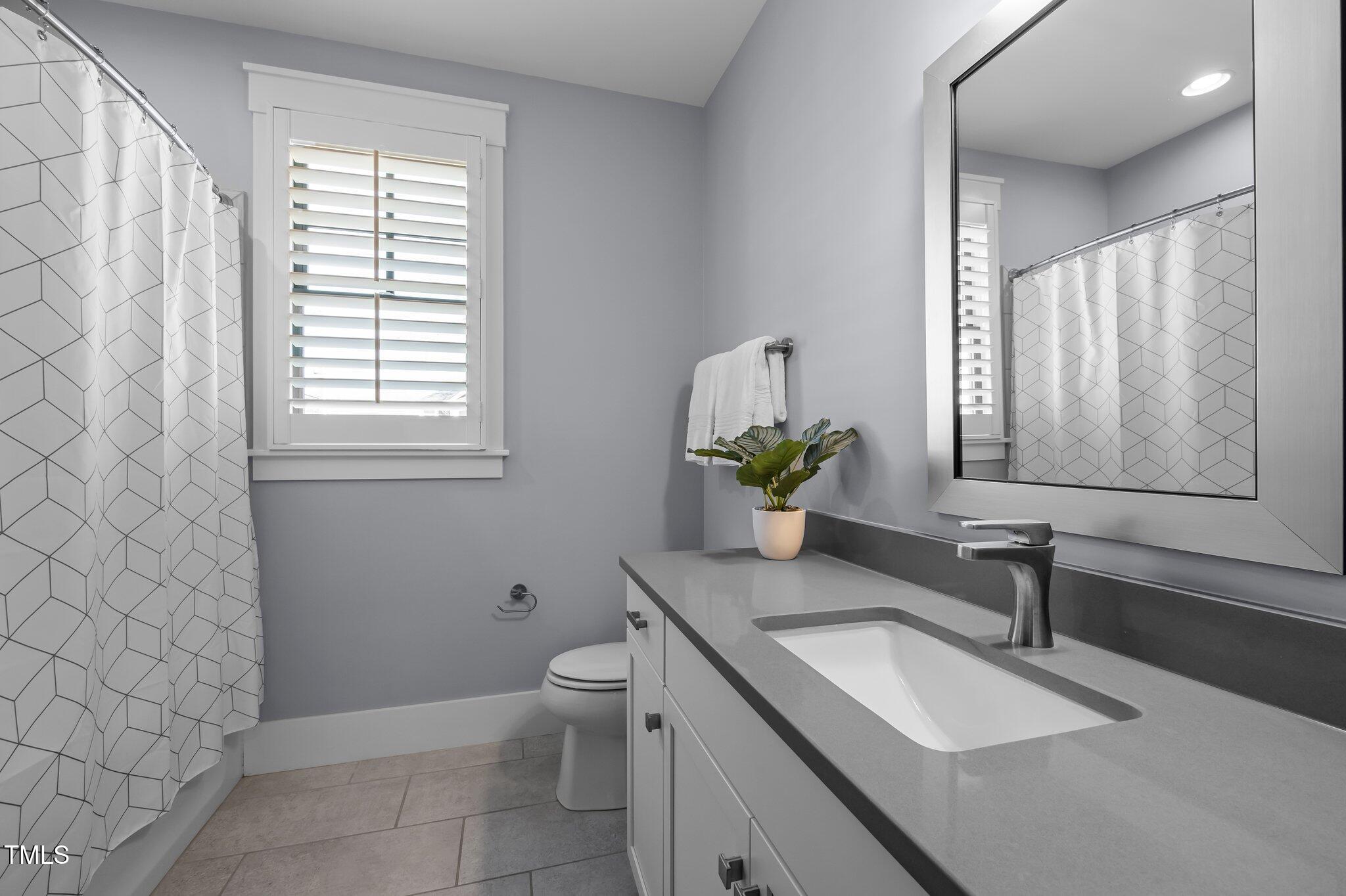 608 Dowd Street Durham, NC 27701 - Photo 16 of 24 a bathroom with a granite countertop sink a toilet and mirror