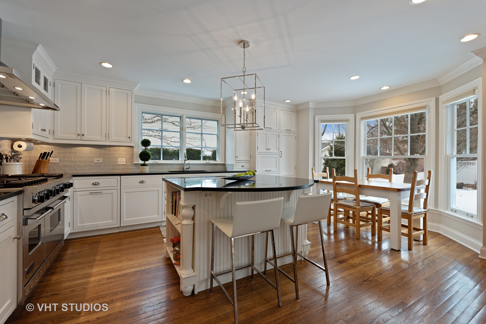 1075 Elm Street Winnetka, IL 60093 - Photo 8 of 40 a kitchen with stainless steel appliances granite countertop a stove top oven a sink dishwasher a dining table and chairs with wooden floor