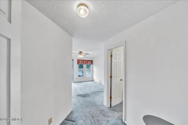 an empty room with windows and chandelier