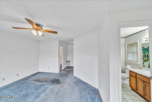 a bathroom with a granite countertop sink a toilet a mirror a vanity and shower