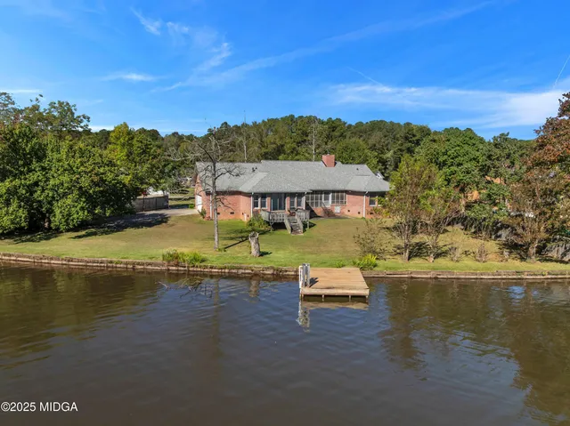 a view of a house with pool and chairs