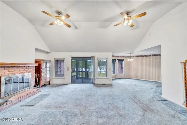 an empty room with fireplace and windows