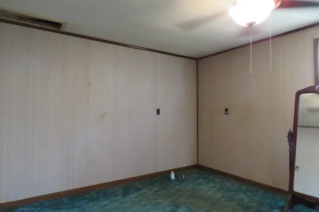 a view of empty room with a fireplace and fan