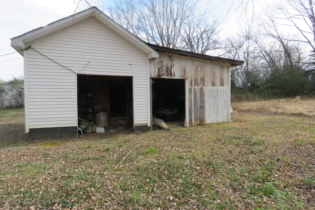 a kitchen with stainless steel appliances granite countertop a refrigerator a sink dishwasher a oven a dining table and chairs with wooden floor