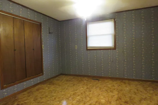 an empty room with windows and closet