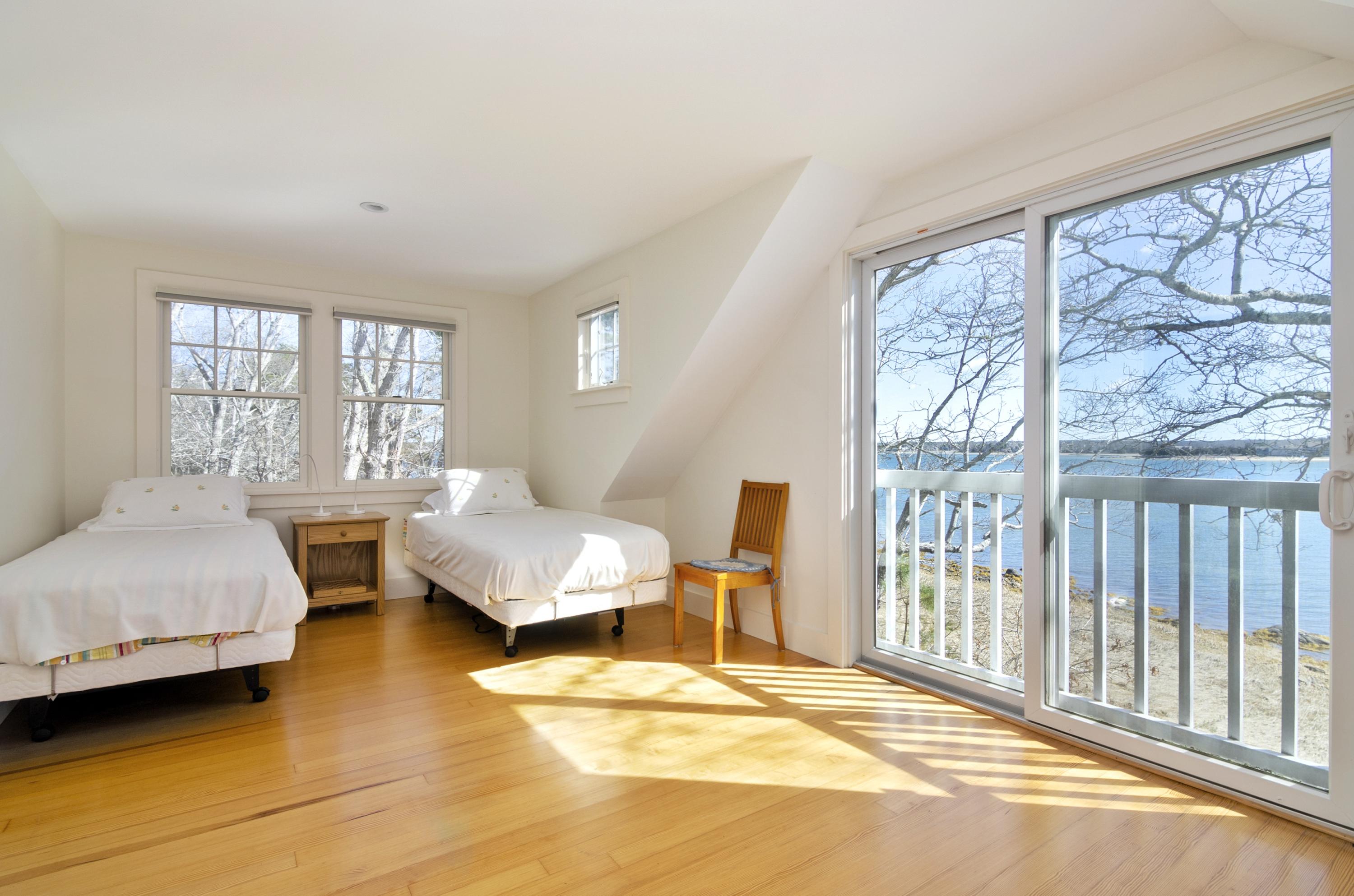 352 Scraggy Neck Road Cataumet, MA 02534 - Photo 17 of 36 a bedroom with a bed and a couch with large window