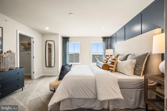 a spacious bedroom with a bed a couch and a dresser