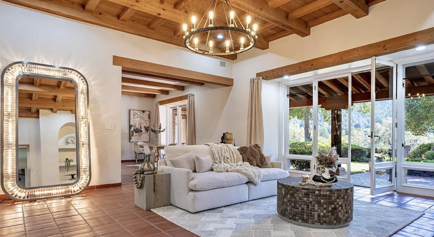 a living room with furniture a chandelier and a large window