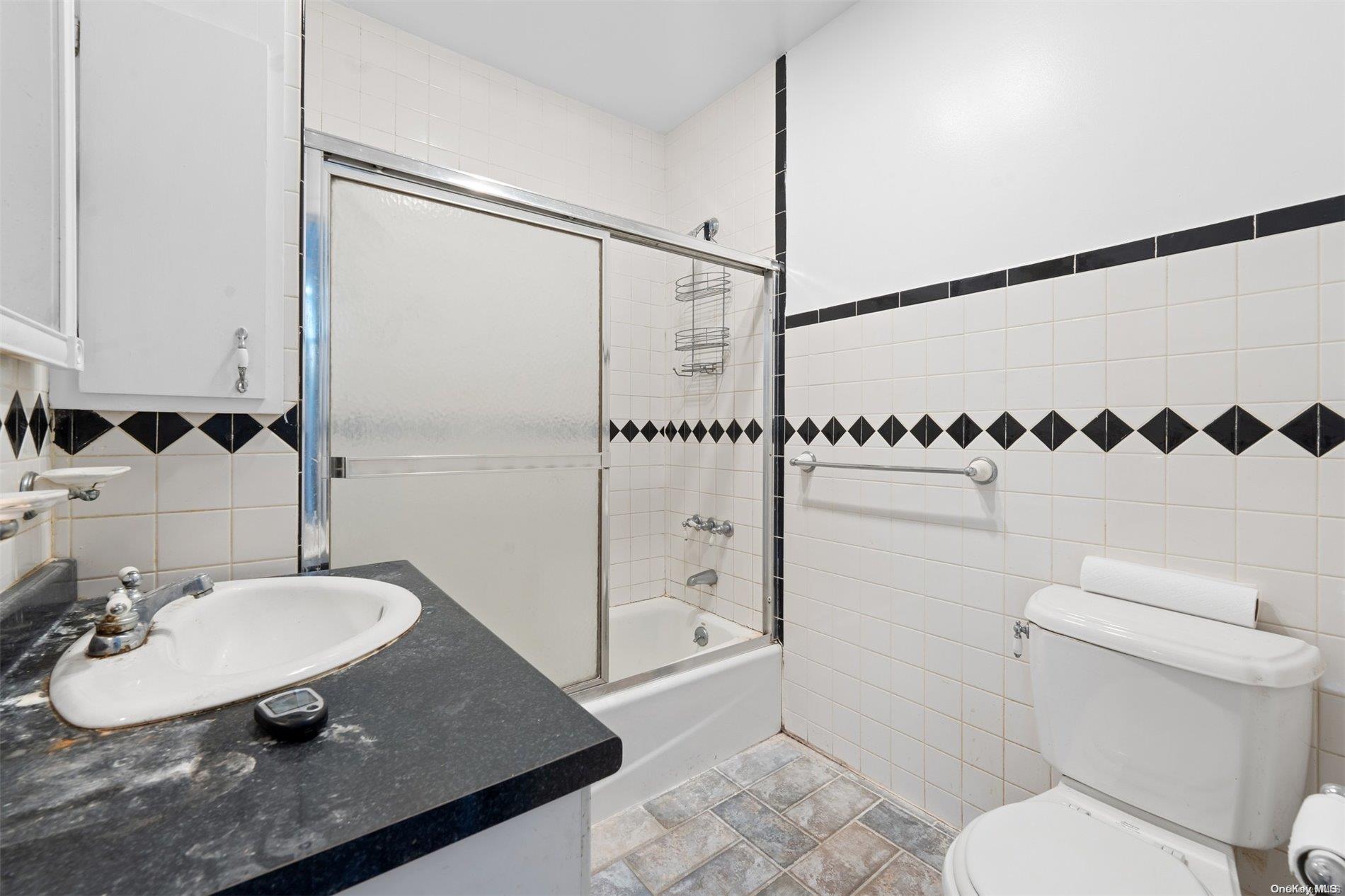 85-70 79th Street Queens, NY 11421 - Photo 14 of 18 a bathroom with a sink a toilet and shower