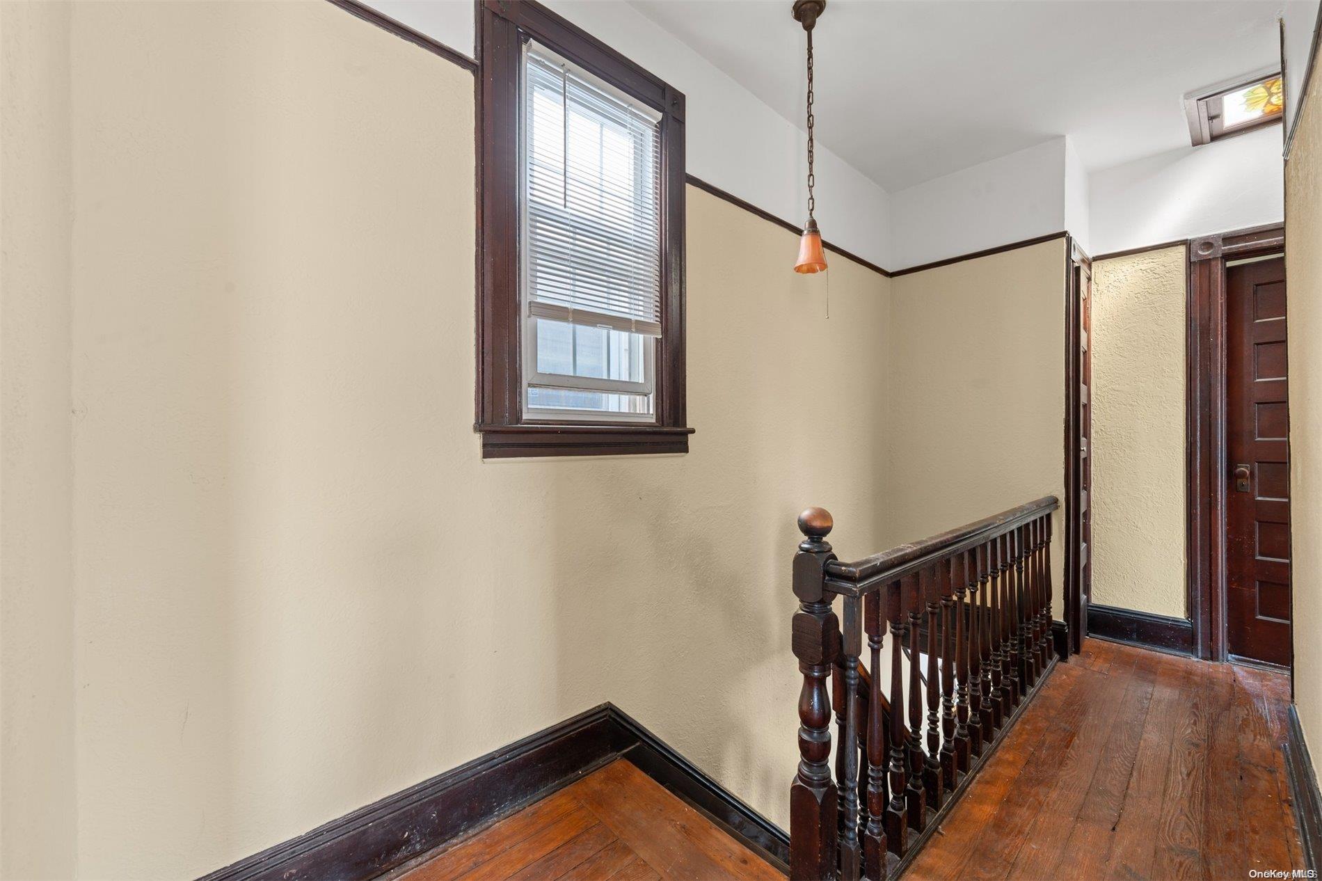 85-70 79th Street Queens, NY 11421 - Photo 9 of 18 a view of a hallway with wooden floor and staircase