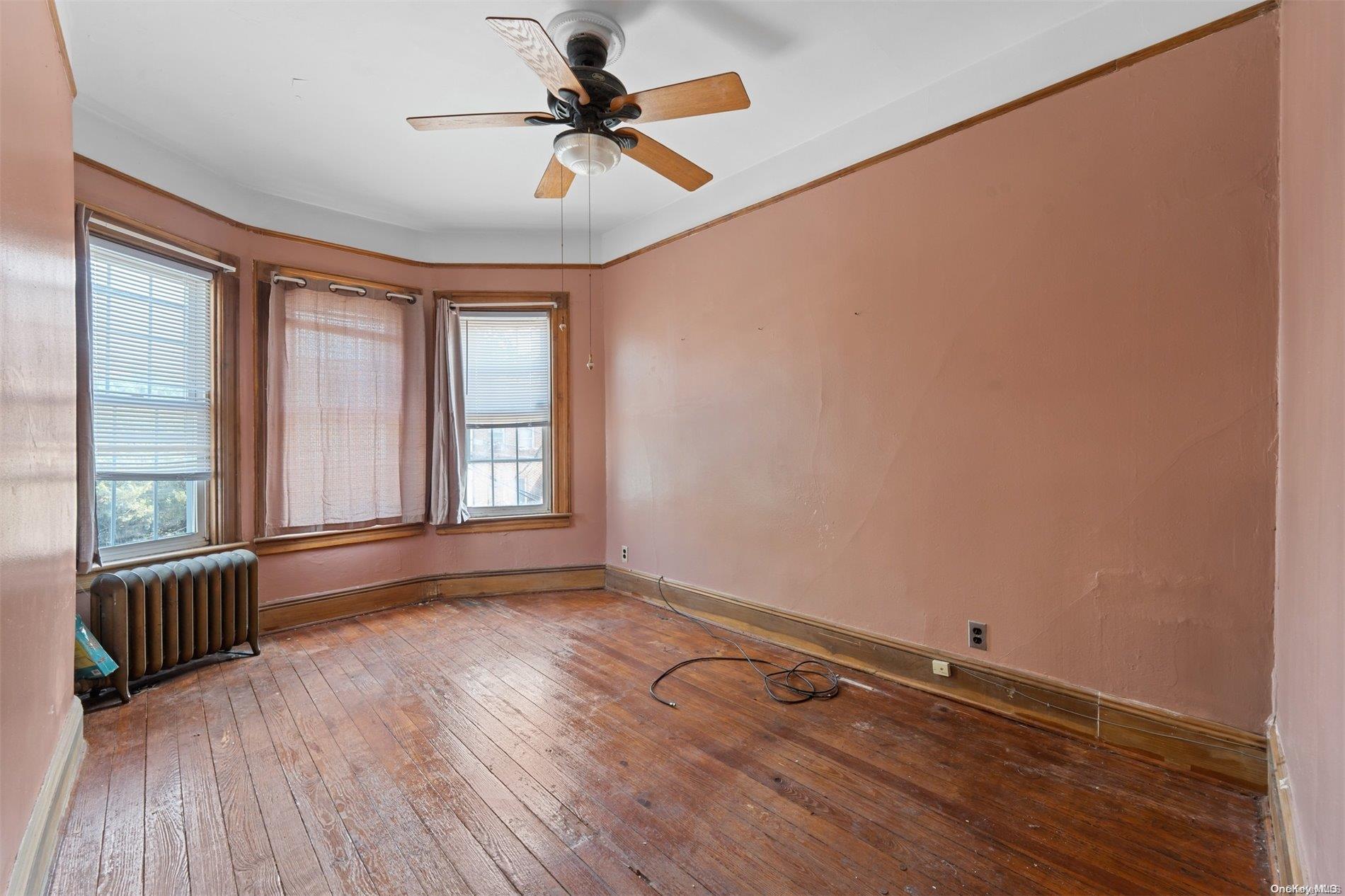 85-70 79th Street Queens, NY 11421 - Photo 10 of 18 a view of an empty room with a window and wooden floor