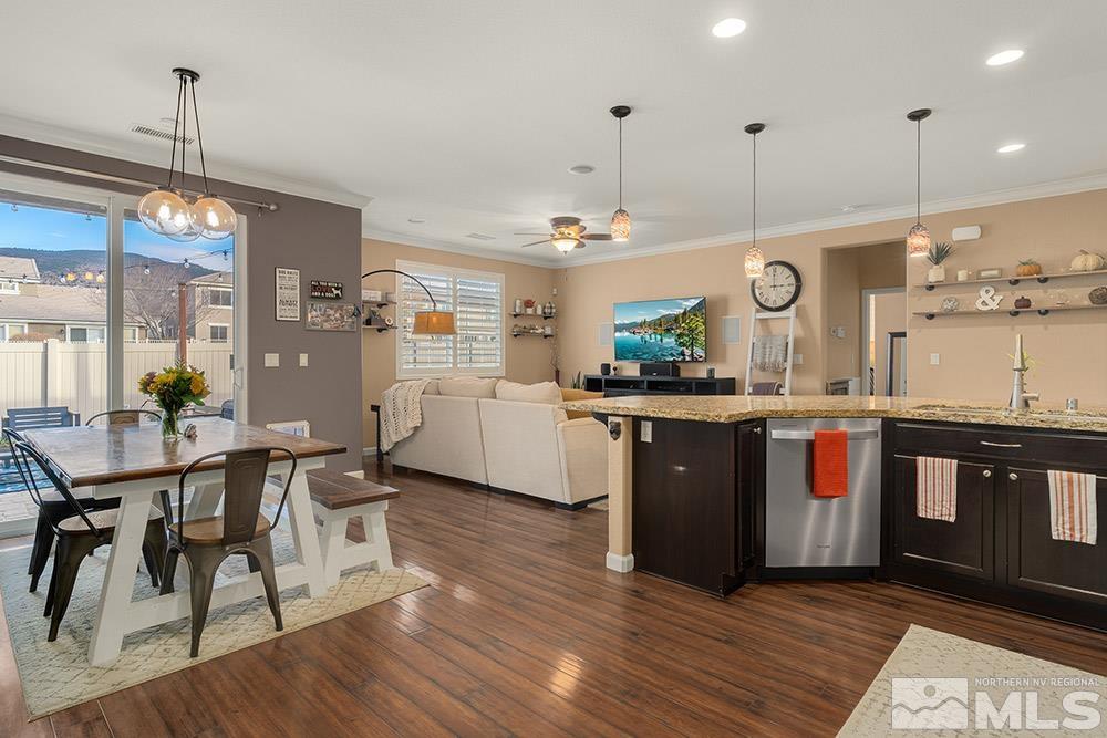 11052 Colton Drive Reno, NV 89521 - Photo 6 of 24 a kitchen with stainless steel appliances granite countertop wooden floors a stove a sink and a refrigerator