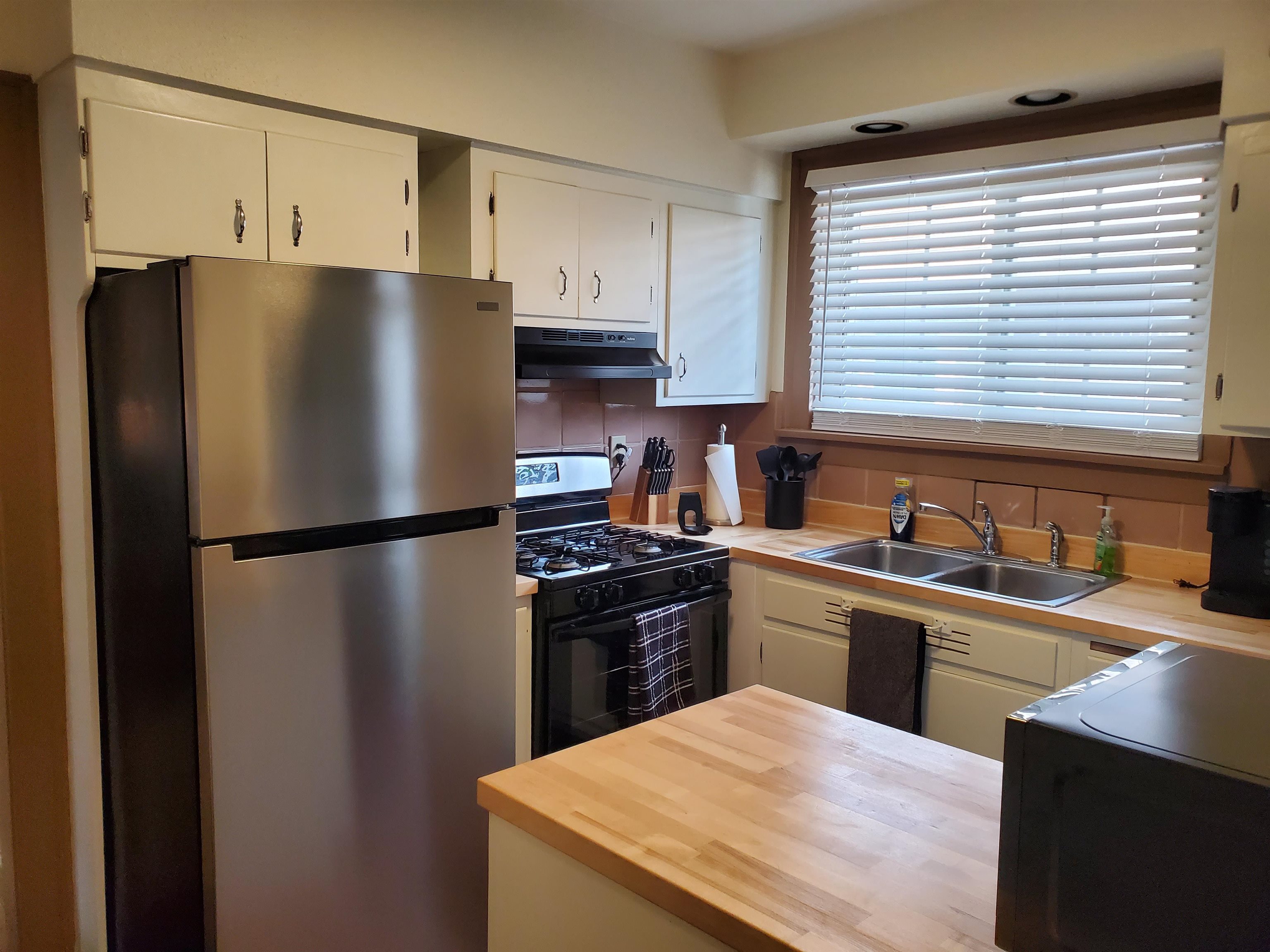 718 Seminary Street Rockford, IL 61104 - Photo 16 of 18 a kitchen with a refrigerator a stove a sink and cabinets