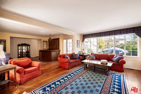 a living room with furniture a rug and a large window