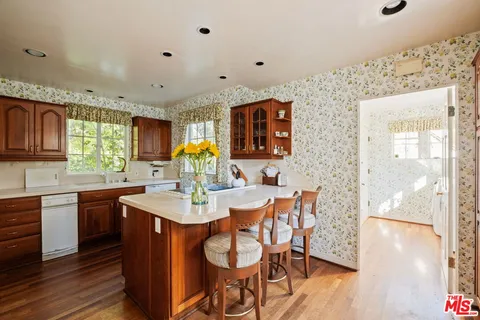 a kitchen with granite countertop a sink cabinets and wooden floor