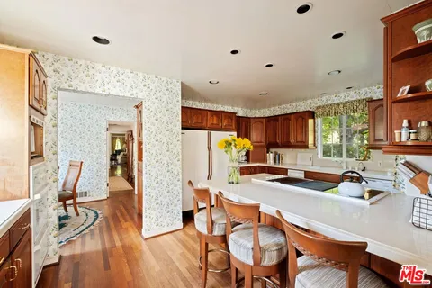 a kitchen with stainless steel appliances refrigerator dining table and chairs