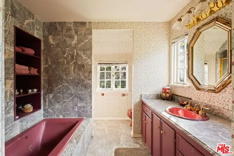 a bathroom with a granite countertop sink mirror vanity and bathtub