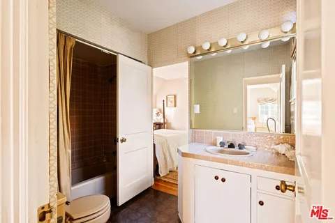 a bathroom with a granite countertop sink toilet and shower