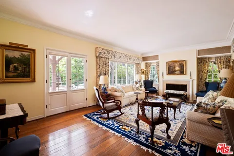 a living room with furniture floor to ceiling window and wooden floor