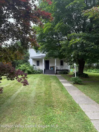 a view of a pathway of a house with a yard