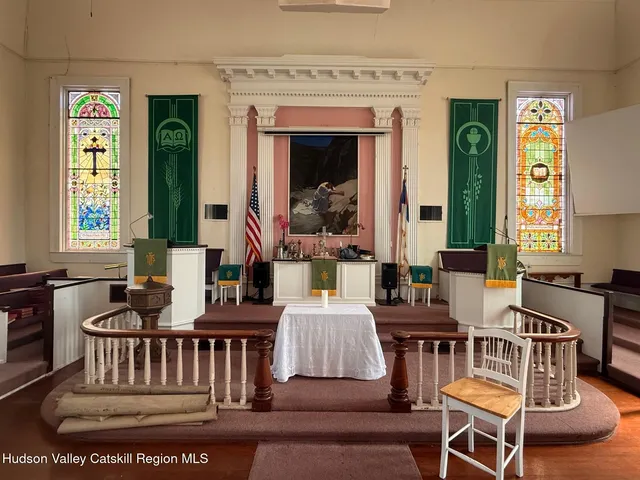 a hallway with a large window and a fireplace