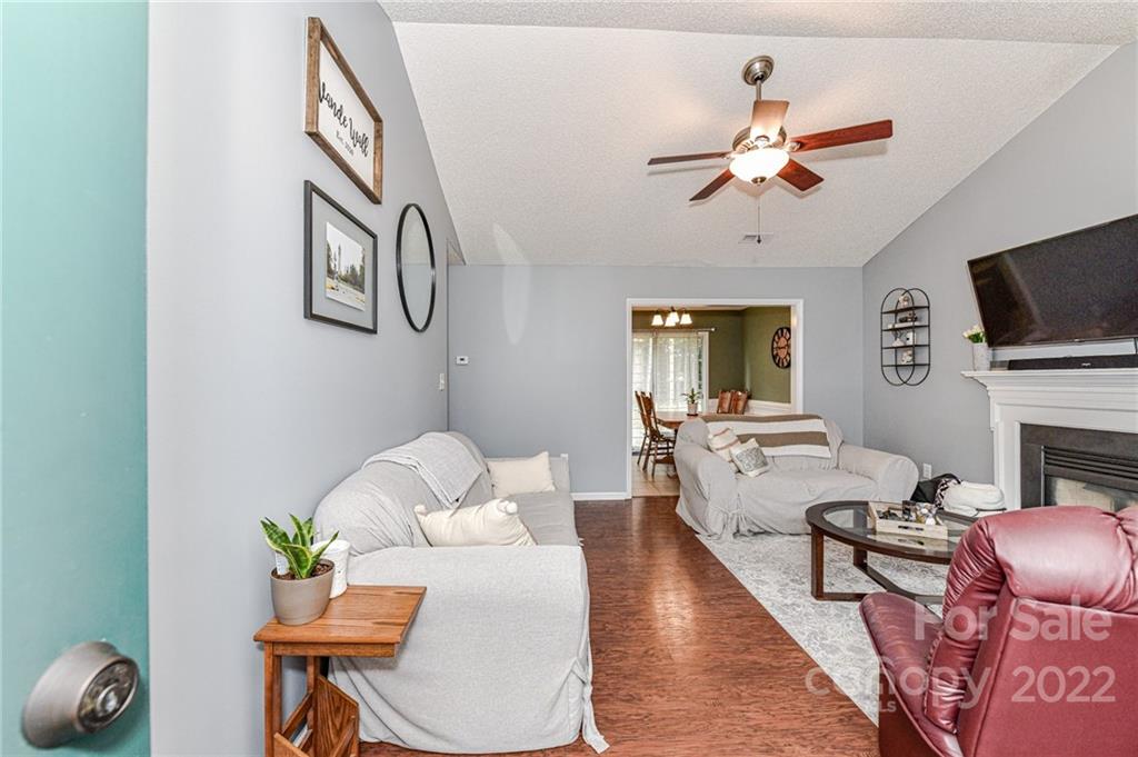 2215 Genesis Drive Monroe, NC 28110 - Photo 4 of 29 a living room with furniture a fireplace and a flat screen tv