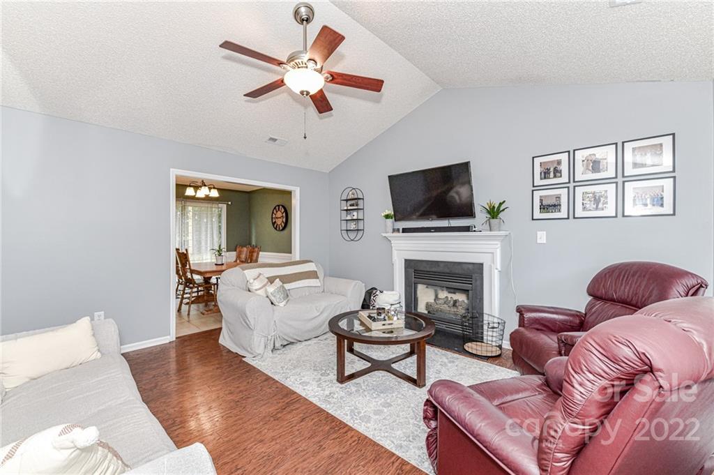 2215 Genesis Drive Monroe, NC 28110 - Photo 6 of 29 a living room with furniture a fireplace and a flat screen tv
