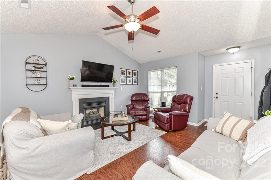 2215 Genesis Drive Monroe, NC 28110 - Photo 7 of 29 a living room with furniture a fireplace and a flat screen tv