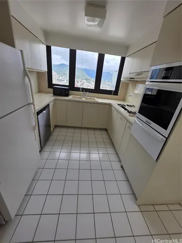 a kitchen with granite countertop a stove a sink and a refrigerator