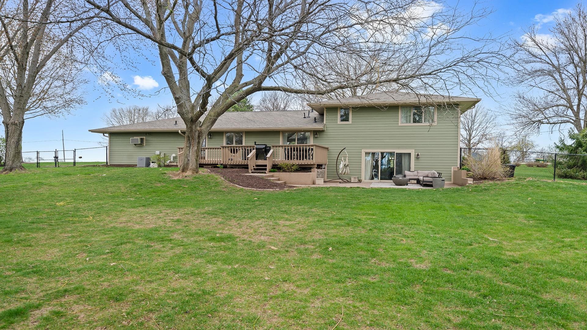 3075 East Water Road Byron, IL 61010 - Photo 40 of 46 a backyard of a house with table and chairs and a large tree