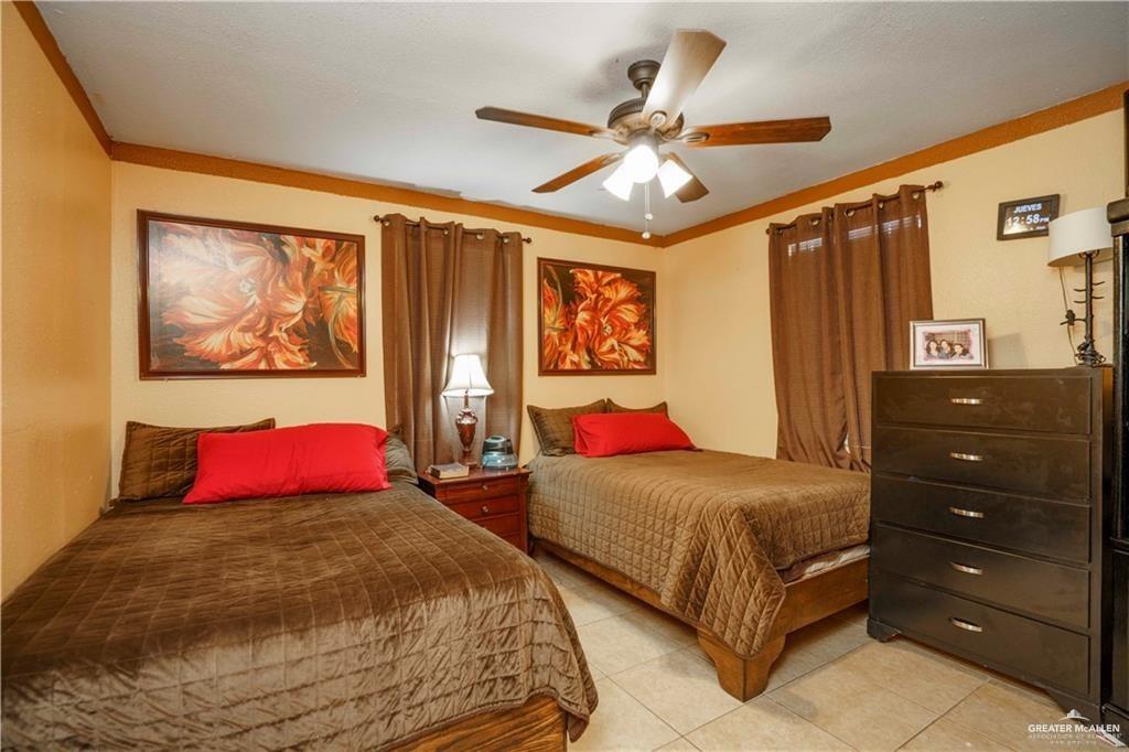15 El Mesquite Lane Rio Grande City, TX 78582 - Photo 12 of 30 a bedroom with a large bed and a chandelier