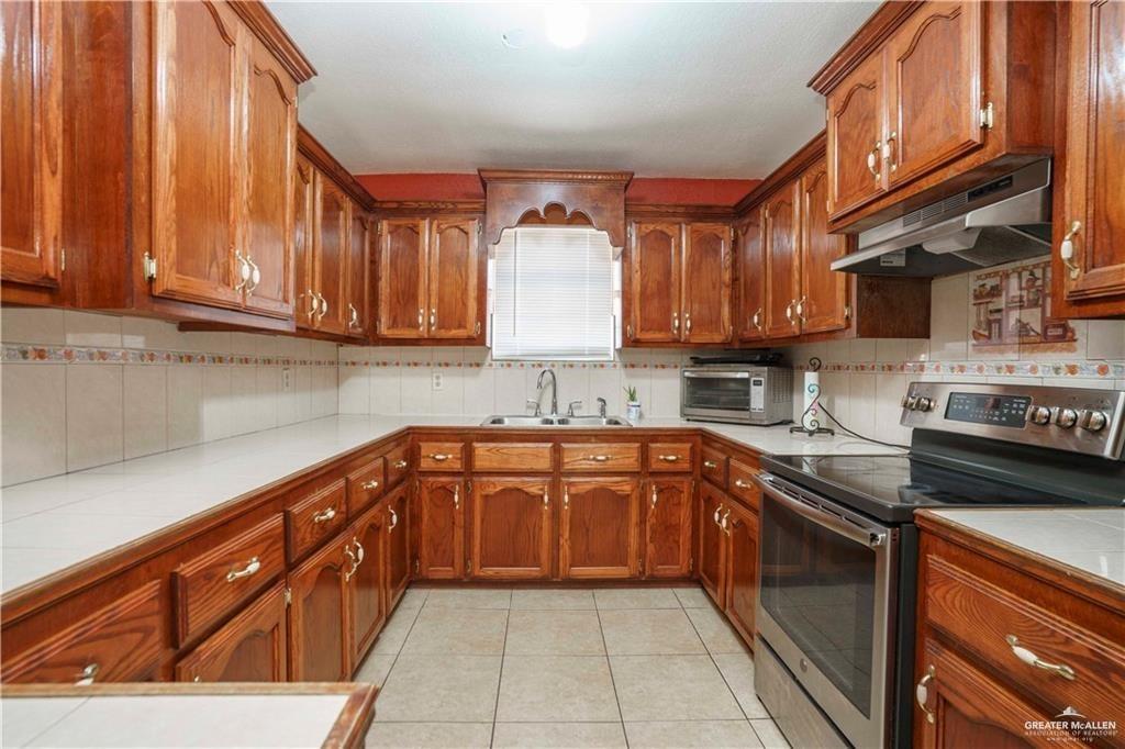 15 El Mesquite Lane Rio Grande City, TX 78582 - Photo 6 of 30 a kitchen with stainless steel appliances granite countertop a sink stove and cabinets