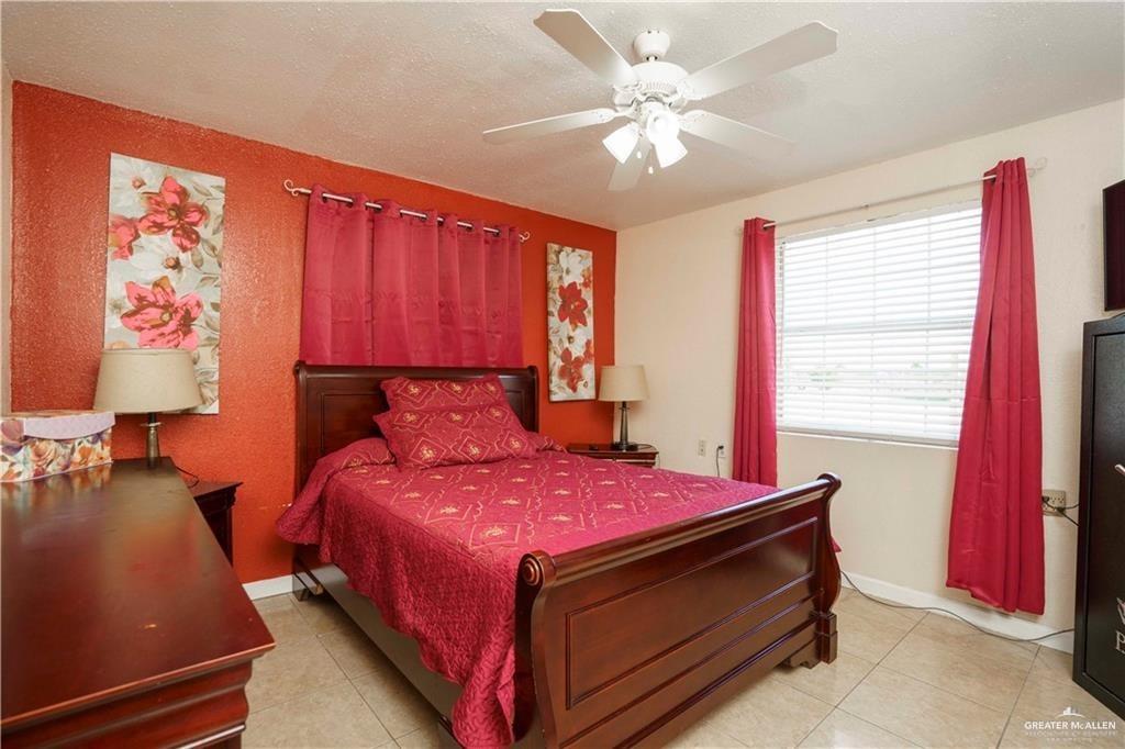 15 El Mesquite Lane Rio Grande City, TX 78582 - Photo 8 of 30 a bedroom with a bed and a chandelier